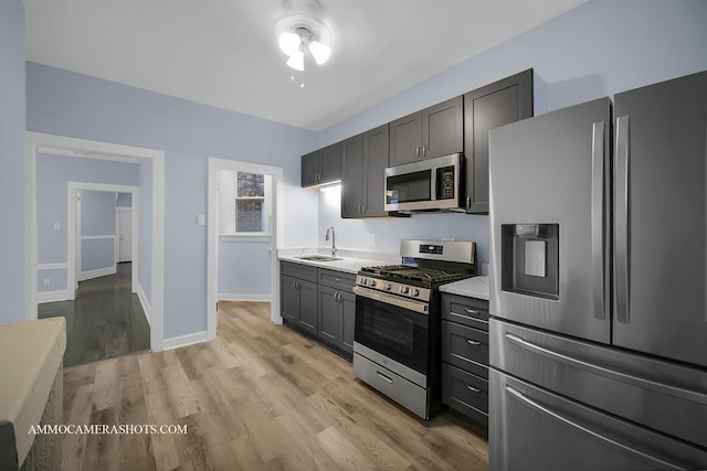 kitchen featuring light wood-type flooring, appliances with stainless steel finishes, and sink