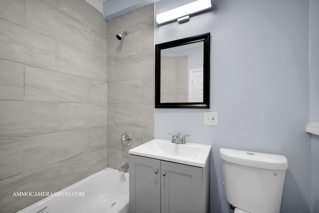 full bathroom featuring toilet, tiled shower / bath, and vanity