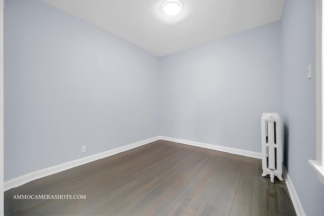 spare room featuring dark hardwood / wood-style flooring and radiator heating unit