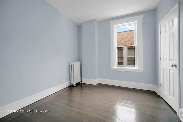 empty room with dark wood-type flooring and radiator heating unit