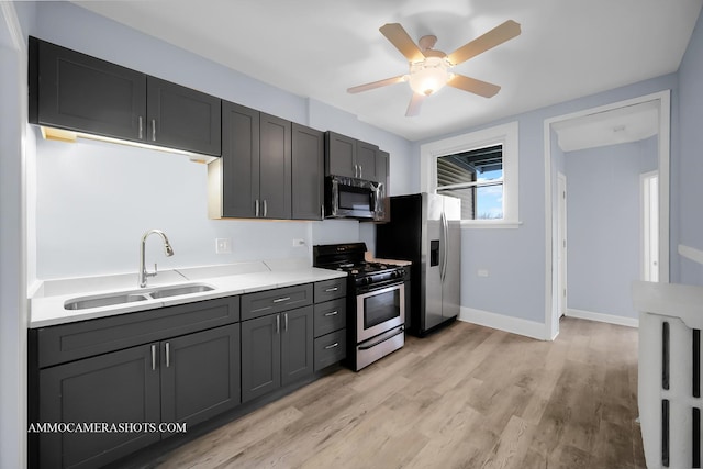 kitchen with ceiling fan, sink, light hardwood / wood-style flooring, and stainless steel appliances