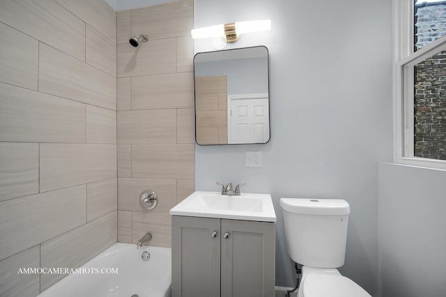 full bathroom with tiled shower / bath combo, vanity, and toilet