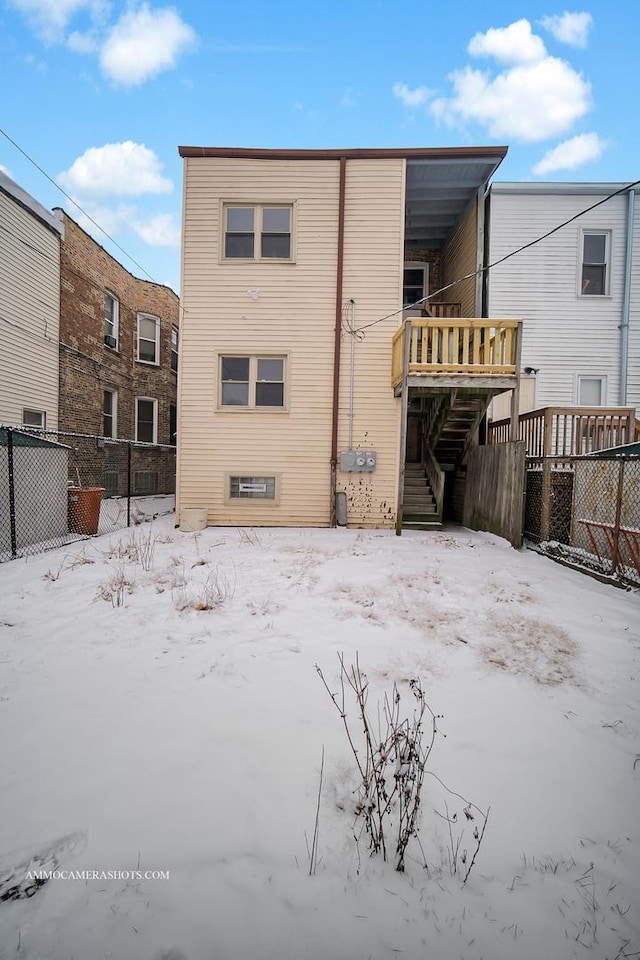 snow covered property with a deck