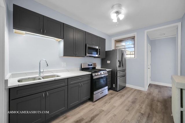 kitchen featuring light hardwood / wood-style floors, sink, light stone counters, and stainless steel appliances