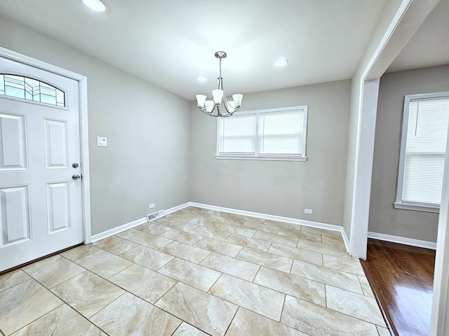 interior space with a notable chandelier and light tile patterned flooring