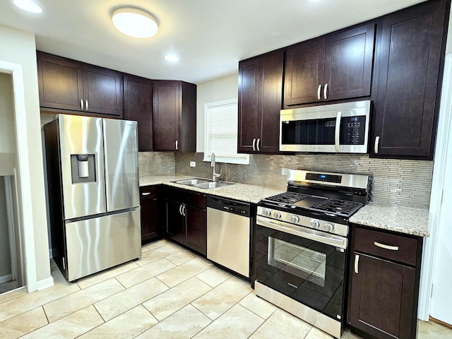 kitchen with appliances with stainless steel finishes, decorative backsplash, dark brown cabinets, and sink