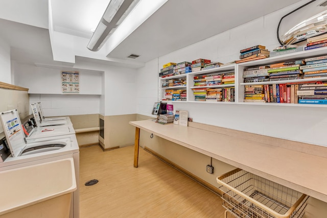 laundry room featuring washer and clothes dryer and light wood-type flooring