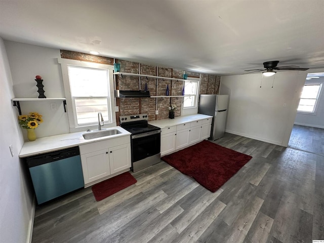 kitchen with dark wood-type flooring, stainless steel appliances, sink, and white cabinets