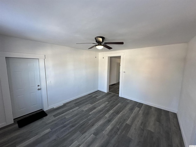 empty room featuring dark wood-type flooring and ceiling fan