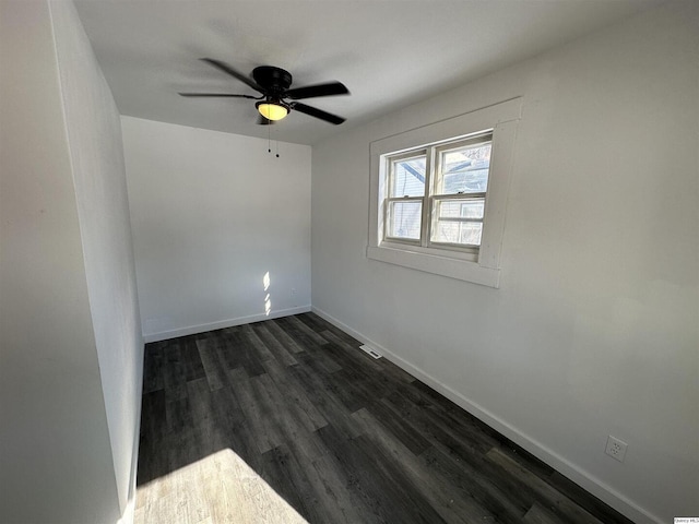 empty room with dark wood-type flooring and ceiling fan