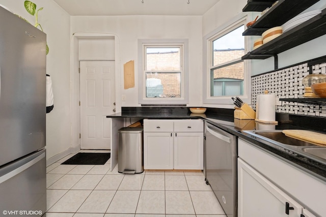 kitchen with appliances with stainless steel finishes, dark countertops, white cabinetry, and open shelves