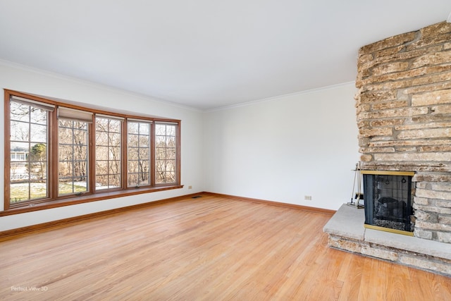 unfurnished living room featuring light hardwood / wood-style floors, crown molding, and a fireplace