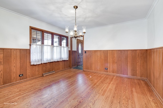 unfurnished dining area with crown molding, an inviting chandelier, a baseboard radiator, and light hardwood / wood-style flooring