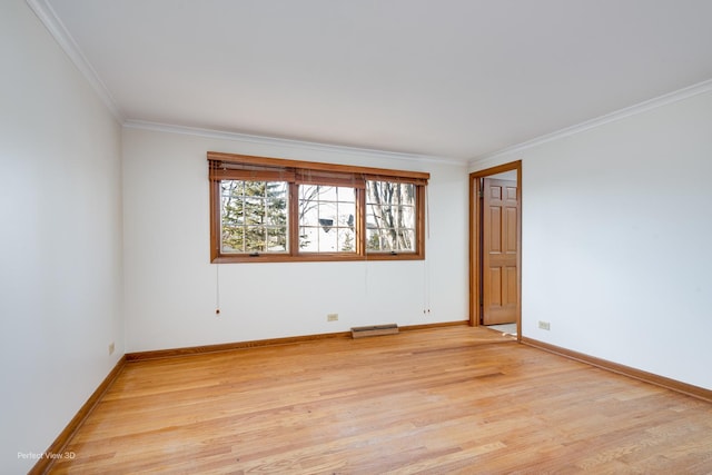 spare room featuring crown molding and light hardwood / wood-style floors