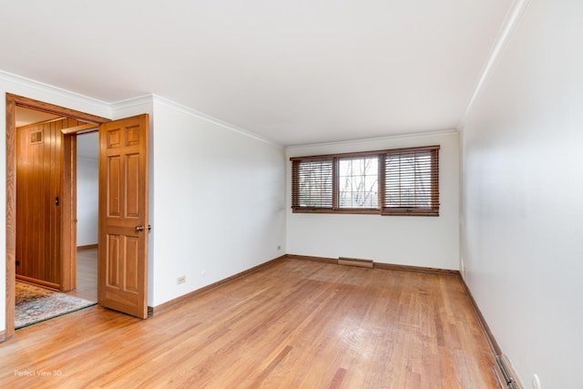 unfurnished room featuring ornamental molding and light hardwood / wood-style flooring