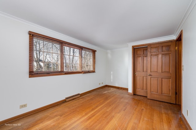 unfurnished bedroom with hardwood / wood-style floors, a closet, and ornamental molding