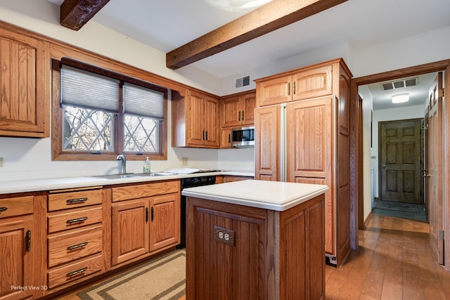 kitchen featuring hardwood / wood-style flooring, sink, dishwasher, beam ceiling, and a center island