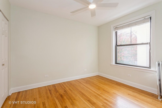 spare room featuring ceiling fan, a healthy amount of sunlight, and light hardwood / wood-style flooring