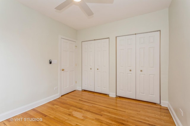 unfurnished bedroom with ceiling fan, multiple closets, and light hardwood / wood-style flooring