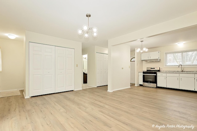 kitchen featuring decorative light fixtures, white cabinets, stainless steel range with gas stovetop, and an inviting chandelier