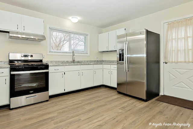 kitchen featuring appliances with stainless steel finishes, light hardwood / wood-style floors, white cabinetry, and sink