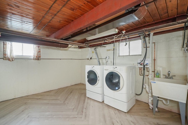 laundry room featuring light parquet floors, washing machine and dryer, and sink