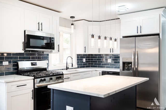 kitchen featuring white cabinetry, hanging light fixtures, and stainless steel appliances