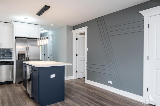 kitchen featuring stainless steel appliances, dark wood-type flooring, pendant lighting, white cabinets, and a center island