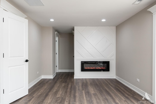 unfurnished living room featuring a fireplace and dark hardwood / wood-style floors