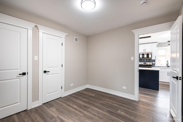 empty room featuring dark hardwood / wood-style floors and sink