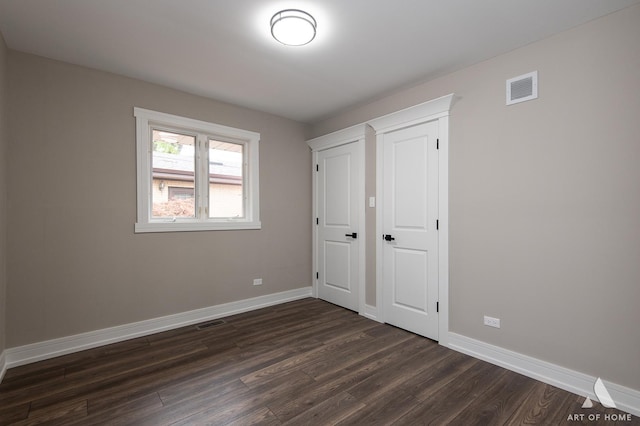 unfurnished bedroom featuring dark hardwood / wood-style floors