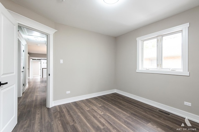 unfurnished room with dark wood-type flooring