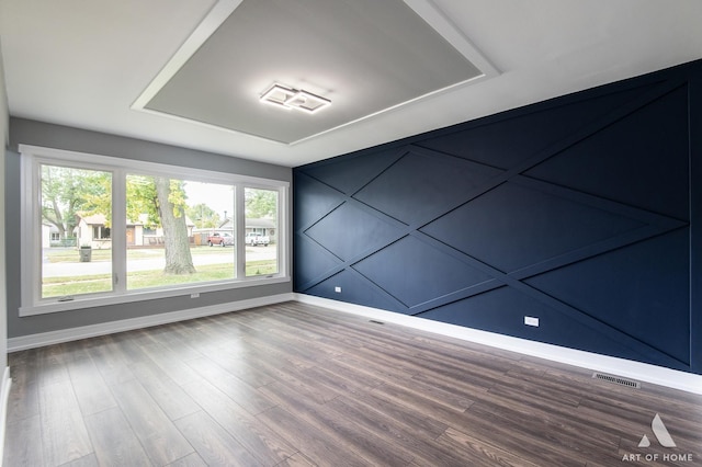 spare room with plenty of natural light and wood-type flooring