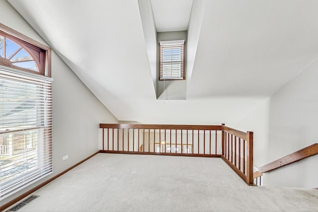 bonus room with lofted ceiling and carpet flooring