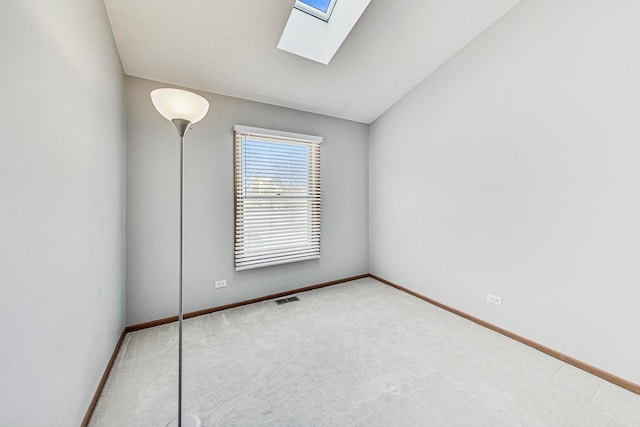 spare room with carpet and vaulted ceiling with skylight