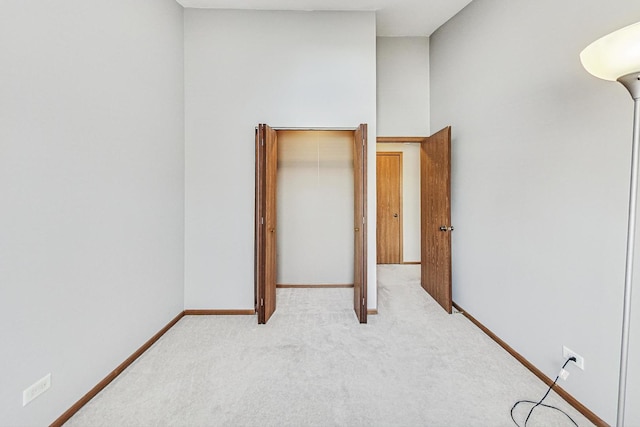 unfurnished bedroom featuring light colored carpet and a closet