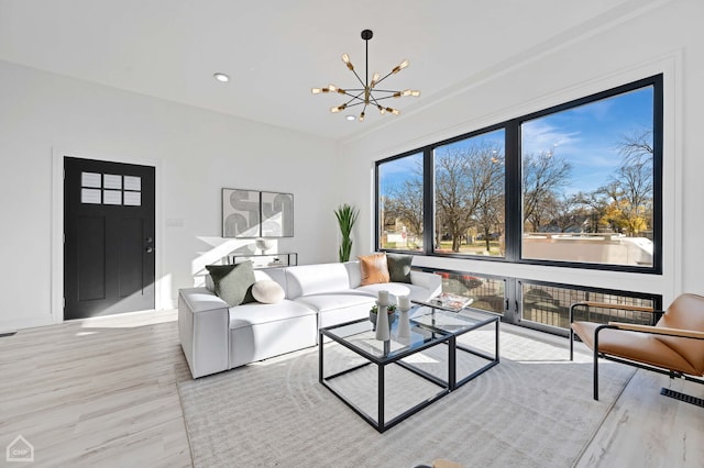 living room with light wood-type flooring and a notable chandelier