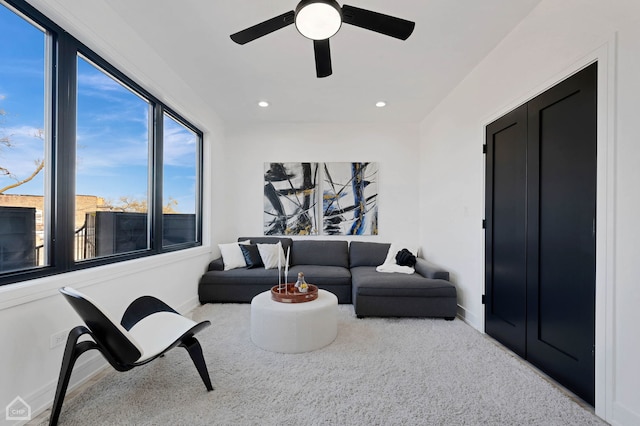 carpeted living room with ceiling fan