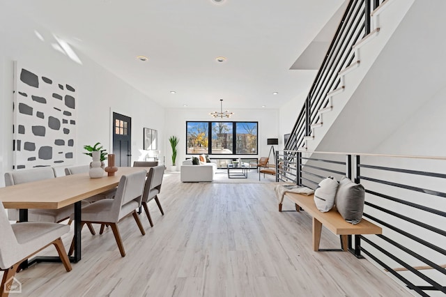 dining area with an inviting chandelier and light hardwood / wood-style flooring