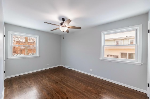 empty room featuring dark wood-type flooring and ceiling fan