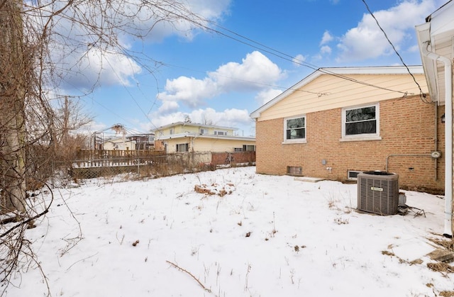 snow covered property with central air condition unit