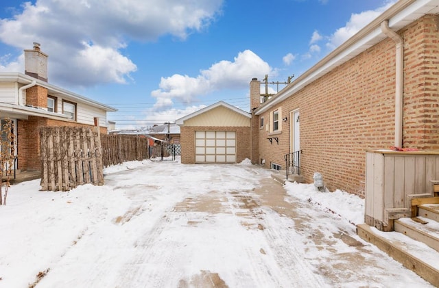 snowy yard with an outdoor structure and a garage