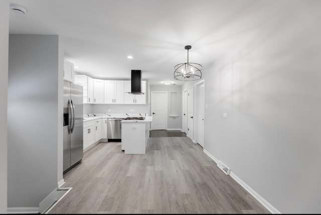 kitchen featuring pendant lighting, a center island, exhaust hood, white cabinetry, and stainless steel appliances