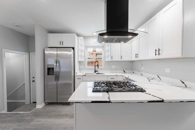 kitchen with white cabinets, stainless steel appliances, sink, island range hood, and light stone counters