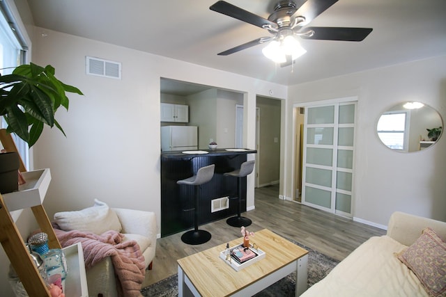 living room with hardwood / wood-style flooring and ceiling fan