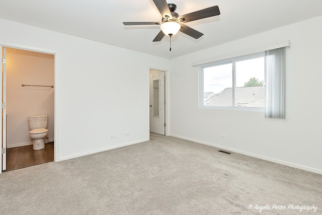 unfurnished bedroom featuring ensuite bath, light colored carpet, ceiling fan, and a closet