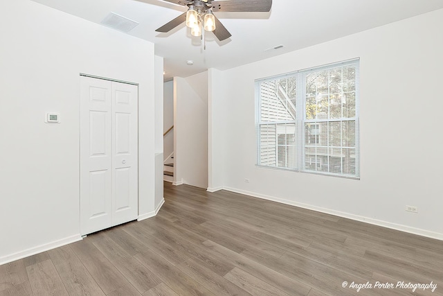 unfurnished bedroom with ceiling fan, a closet, and hardwood / wood-style floors