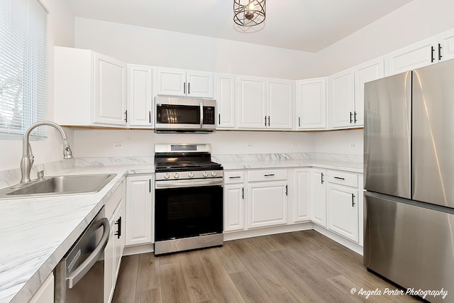 kitchen featuring light hardwood / wood-style flooring, sink, stainless steel appliances, and white cabinetry