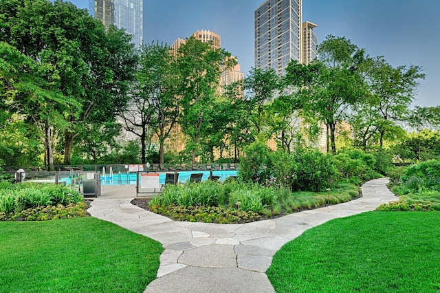 view of community featuring a pool and a lawn