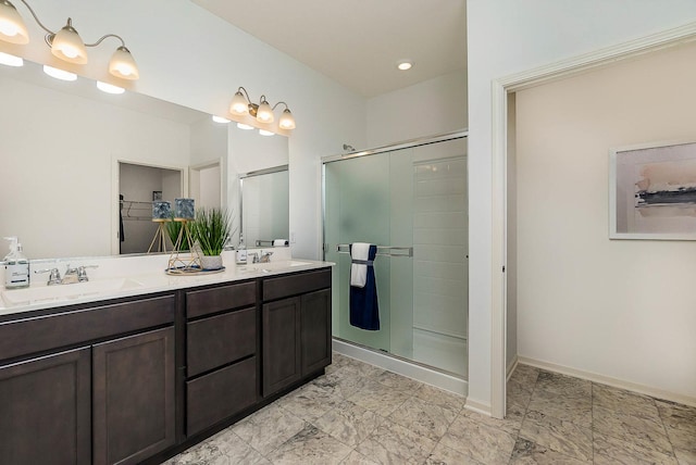 bathroom featuring a shower with shower door and vanity